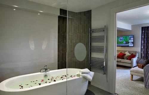 La salle de bains est pourvue d'une baignoire avec des fleurs. dans l'établissement Sligo Park Hotel & Leisure Club, à Sligo