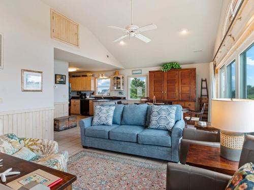 a living room with a blue couch and a kitchen at 3014 - Endless Horizons in Duck