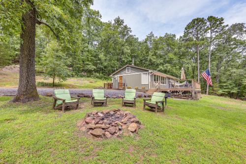 a group of chairs and a fire pit in front of a cabin at Treetop Hideaway with Lake Views and Fire Pit! in Fairfield Bay