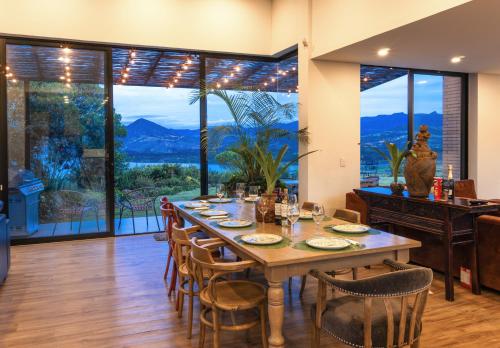 a dining room with a table and chairs and large windows at La Dolce Vita, Guatavita in Guasca