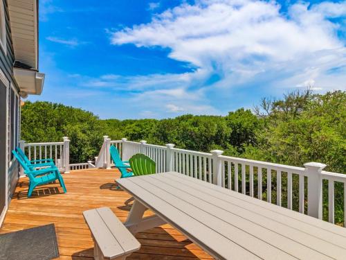 a wooden deck with chairs and a picnic table at 2072 - Laughing Duck in Duck
