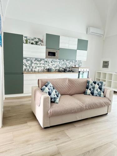 a living room with a couch and a kitchen at Holiday House Marsala in Marsala