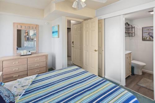 a bedroom with a bed and a bathroom at 6133 - Coastal Crave in Nags Head