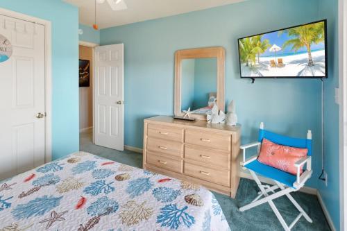 a bedroom with a bed and a dresser and a mirror at 6133 - Coastal Crave in Nags Head