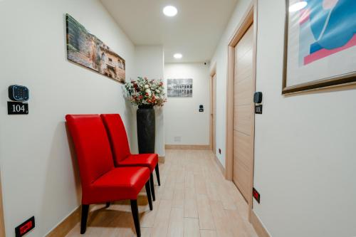 a hallway with red chairs and a vase of flowers at Independent Rooms in Verona