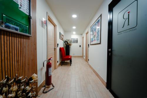 a hallway with a red chair and a hallway with a corridorngthngthngthngth at Independent Rooms in Verona