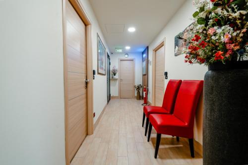 a hallway with a red chair and a corridor with a hallway at Independent Rooms in Verona