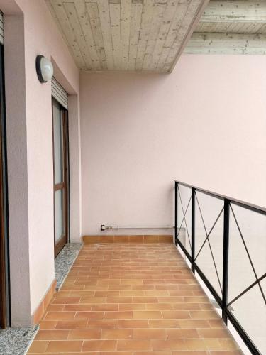 a hallway with a white wall and a black railing at Helena home in Torre De' Roveri