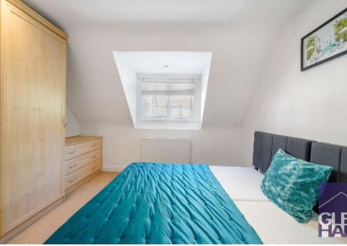 a bedroom with a bed and a dresser and a window at The Mews, N14 in New Southgate