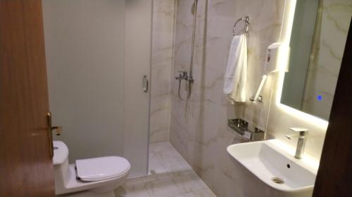 a bathroom with a toilet and a sink and a shower at فندق منازل روز in Al Lith