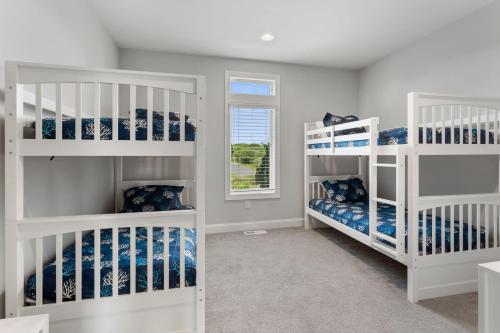 a room with white bunk beds and a window at 3025 - Who's On First in Southern Shores