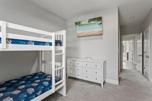a bedroom with two bunk beds and a desk at 3025 - Who's On First in Southern Shores