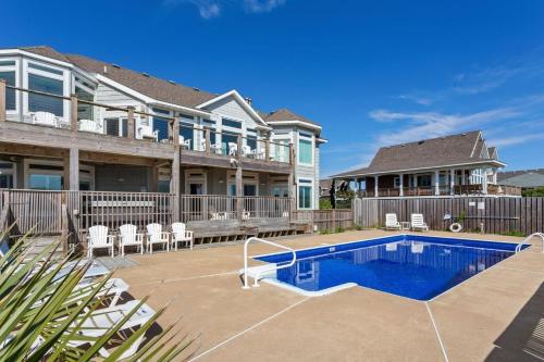 a house with a swimming pool in front of a house at 3025 - Who's On First in Southern Shores