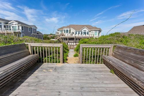 two benches on a boardwalk in front of some houses at 3025 - Who's On First in Southern Shores
