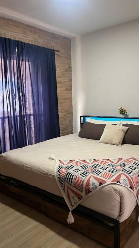 a large bed in a bedroom with a window at El Rincón de Monte Alban in Oaxaca City
