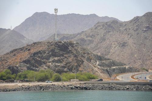 a mountain with a road on top of it next to the water at Al Dana Sea Luxury Villa Fujairah in Sharm