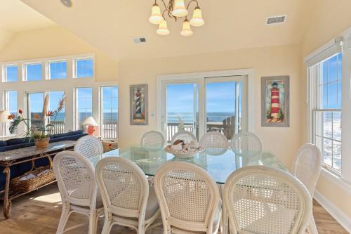 a dining room with a glass table and chairs at 8046 - Sun Runner in Rodanthe