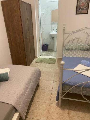 a small bedroom with a bed and a bathroom at Sunset Villa Apartments Alepokhori in Káto Alepokhórion