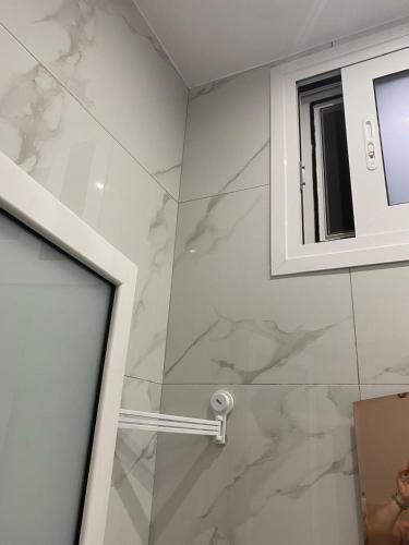 a bathroom with a shower with marble tiles at Sunset Villa Apartments Alepokhori in Káto Alepokhórion
