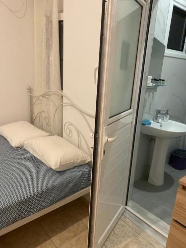 a small bathroom with a shower and a sink at Sunset Villa Apartments Alepokhori in Káto Alepokhórion