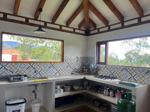 a kitchen with a counter and two windows at Casa Silvestre in Villa de Leyva