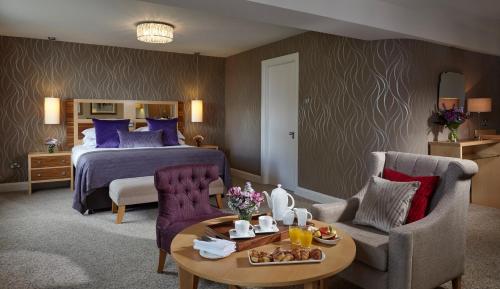 a hotel room with a bed and a table and chairs at Sligo Park Hotel & Leisure Club in Sligo