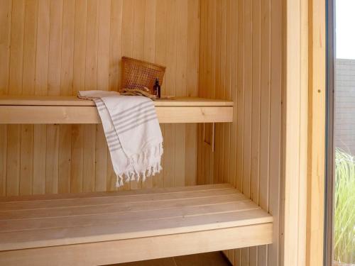 a wooden sauna with a towel on a shelf at 5 star holiday home in Rømø in Kongsmark