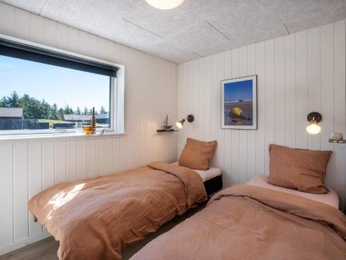 two beds in a room with a window at 5 star holiday home in Rømø in Kongsmark