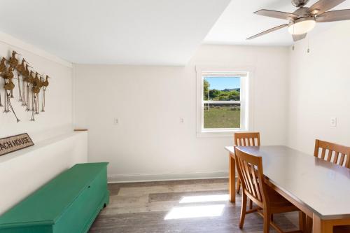 a dining room with a green table and a window at 3018 - Celestial Mermaid in Southern Shores