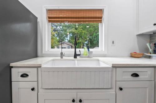 a white kitchen with a sink and a window at Casa Madeore Luxury Bungalow in St. Augustine