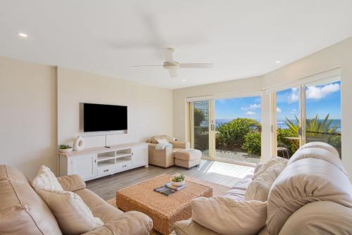 a living room with a couch and a flat screen tv at Tahnee Court Unit 3 in Gold Coast
