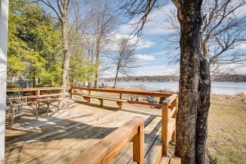 a wooden dock with benches and a tree at Dock and Sunroom Waterfront Home Near Kalahari! in Pocono Summit