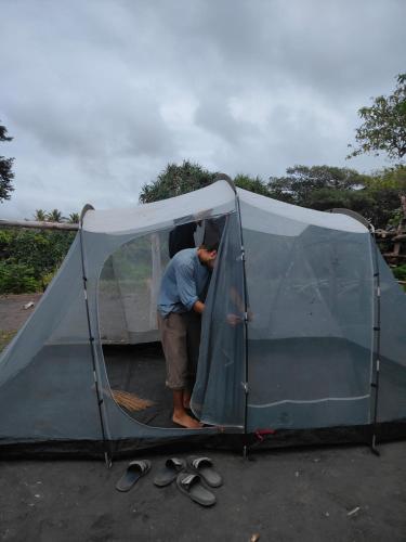 a man is standing inside of a tent at Montanna Lodge in White Sands