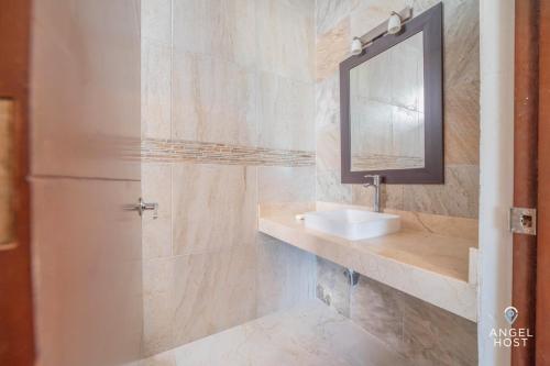 a bathroom with a sink and a mirror at Beachfront Villas with Private Pool Steps to the Sea! in Chicxulub