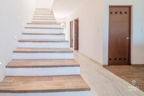 a staircase in a house with white walls and wooden floors at Beachfront Villas with Private Pool Steps to the Sea! in Chicxulub