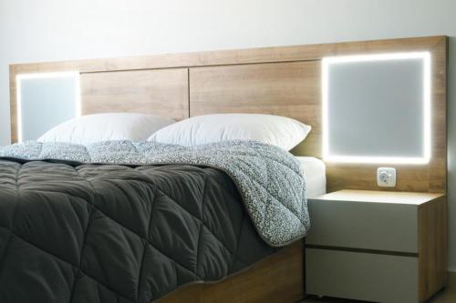 a bed with a wooden headboard and white pillows at ICOSIUM House ALGER in Birkhadem