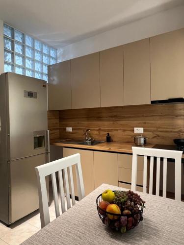 a kitchen with a table with a bowl of fruit on it at Arsi Beach House Rrjoll 2 in Baks-Rrjoll