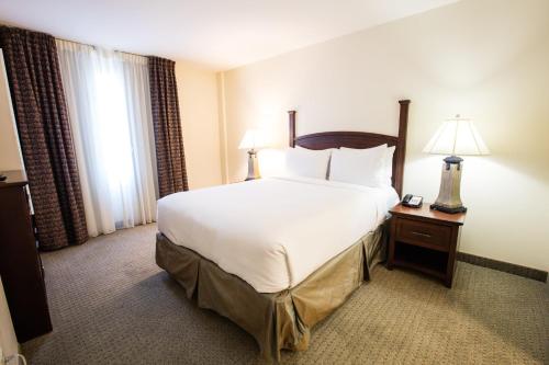 a hotel room with a large bed and two lamps at Staybridge Suites Austin Airport by IHG in Austin