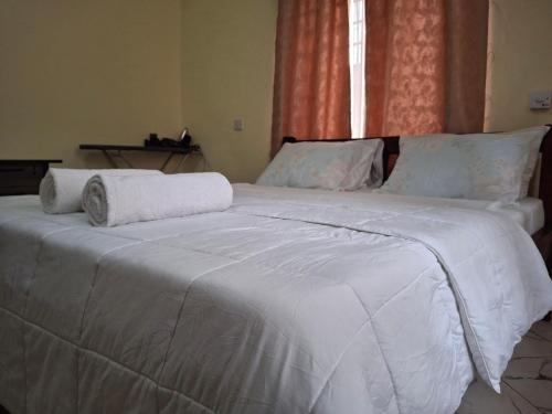 a large white bed with two towels on it at Zai Homes Watamu in Watamu
