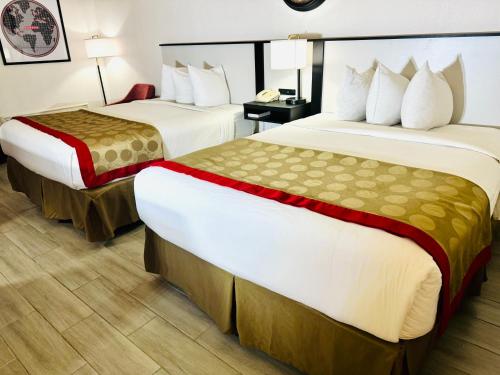 a hotel room with two beds and a desk at Ramada by Wyndham Birmingham Airport in Birmingham