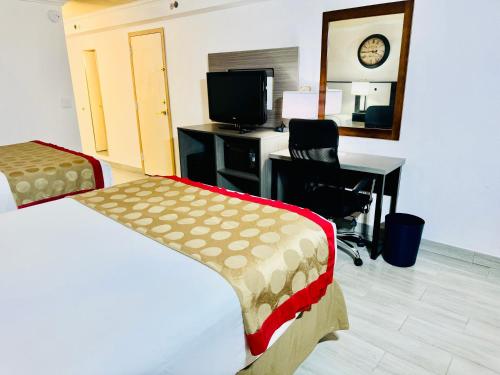 a hotel room with a bed and a desk with a computer at Ramada by Wyndham Birmingham Airport in Birmingham