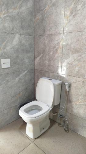 a bathroom with a white toilet in a wall at Pousada Pinima Xperience in Goianesia do Para