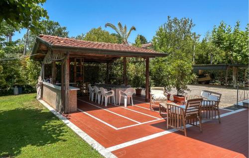 a patio with a gazebo with chairs and tables at Gorgeous Home In Poveromo With Wifi in Cinquale