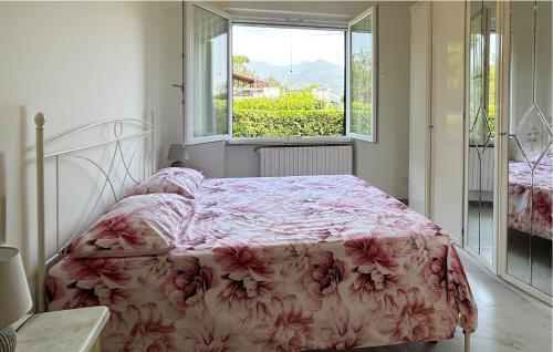a bedroom with a bed with a floral bedspread and a window at Gorgeous Home In Poveromo With Wifi in Cinquale