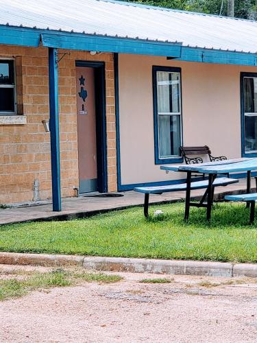 a picnic table in front of a building at Hill Country Lodge and Mini Storages in Buchanan Dam