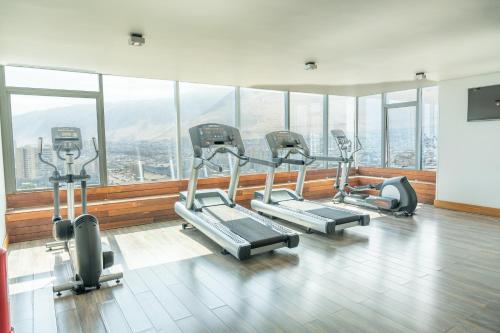 a gym with several treadmills in a room with windows at Hotel Terrado Cavancha in Iquique