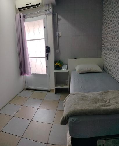 a bedroom with a bed and a window and a door at Pernoitar in São José