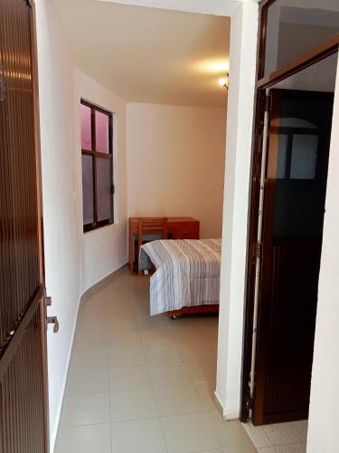 a hallway leading to a bedroom with a bed at Casa Villa Real in Toluca
