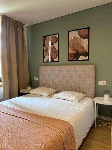 a bedroom with a bed with three pictures on the wall at Porbálio Oporto & Maia Center #1 in Leça do Balio