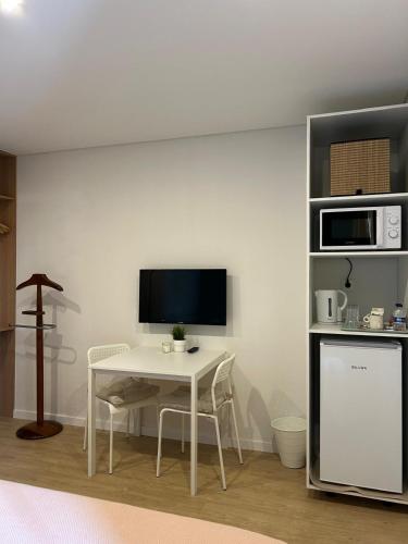 a white room with a table and a television at Porbálio Oporto & Maia Center #1 in Leça do Balio
